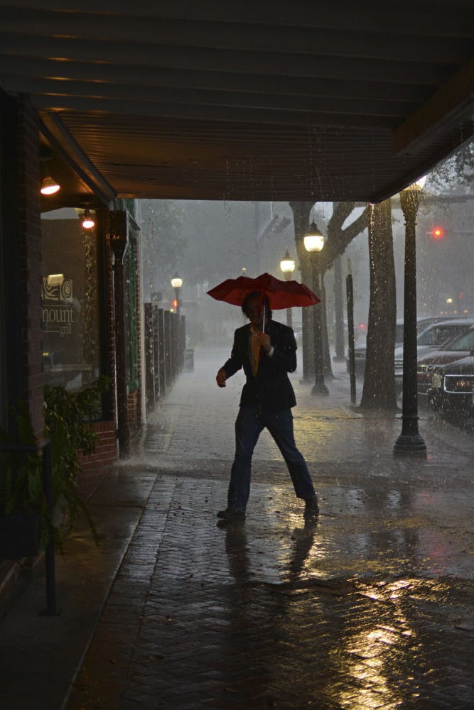 Anthony De Lamarter takes shelter from the rain in downtown Gainesville on Sunday.