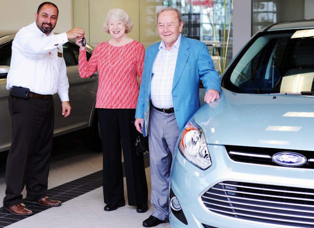 <p>Michael Grimaldi, General Sales Manager of Parks Ford Lincoln of Gainesville, hands the keys to a 2014 Ford C-MAX Hybrid to Albert Traversa and his wife Mary Hausler.</p>