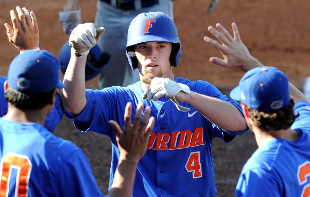 Florida's Nolan Fontana is congratulated after raking a game-tying two-run homer in the Gators 3-2 win over Georgia in the semifinals of the SEC baseball tournament at Regions Park in Hoover, Ala. on Saturday.