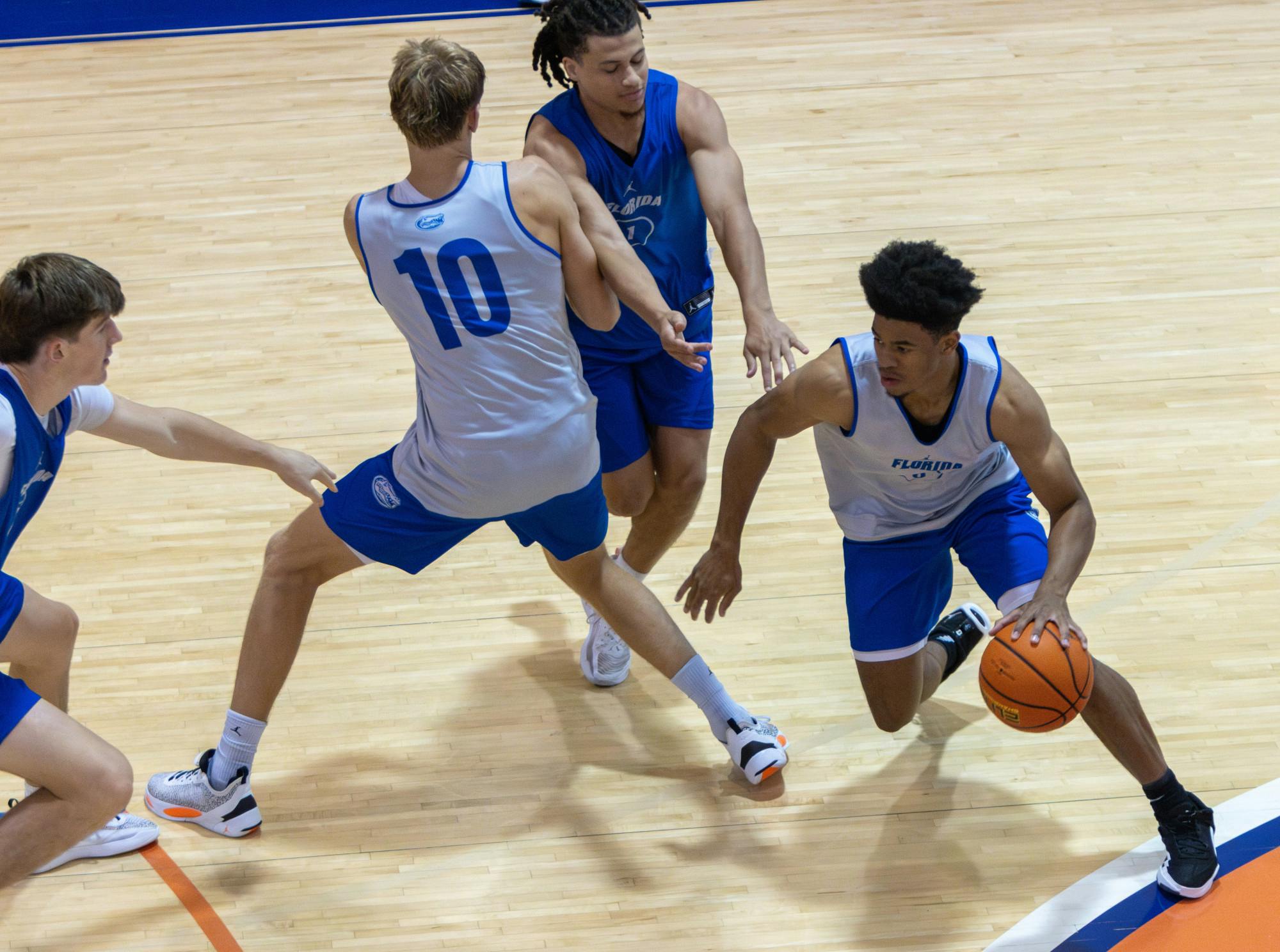 Graduate student guard Zyon Pullin dribbles around a screen during the Florida Gators Mens Basketball open practice on Tuesday, Sept. 26, 2023. 