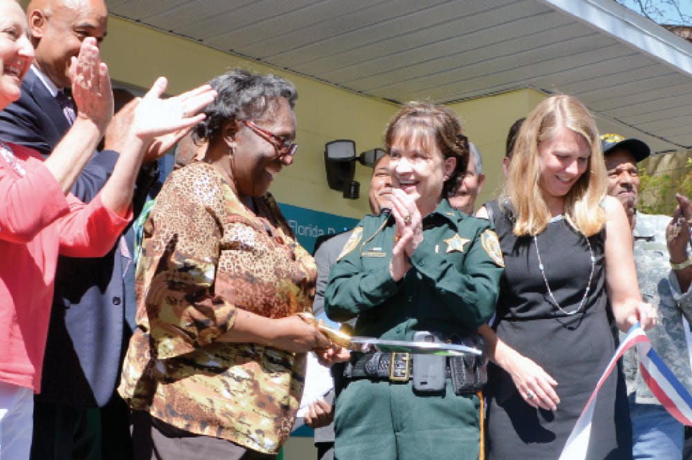 Joan Canton, vice chair of Southwest Advocacy Group, cuts the ribbon in front of the new Southwest Health Clinic at 816 SW 64th Terrace. The clinic, which will offer health care services to Linton Oaks and surrounding neighborhoods, opens Tuesday.