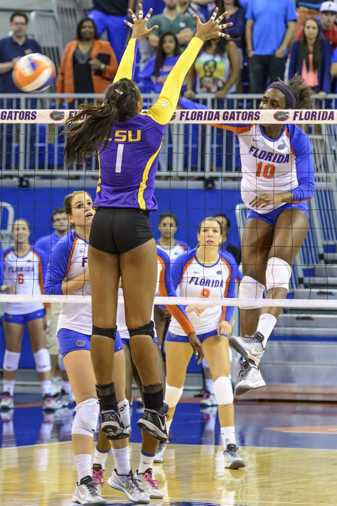 Redshirt senior middle blocker Chloe Mann spikes the ball, after a set-up by fellow senior Taylor Brauneis, for the match-winning kill during No. 7 Florida's sweep of LSU on Friday night in the O'Connell Center.