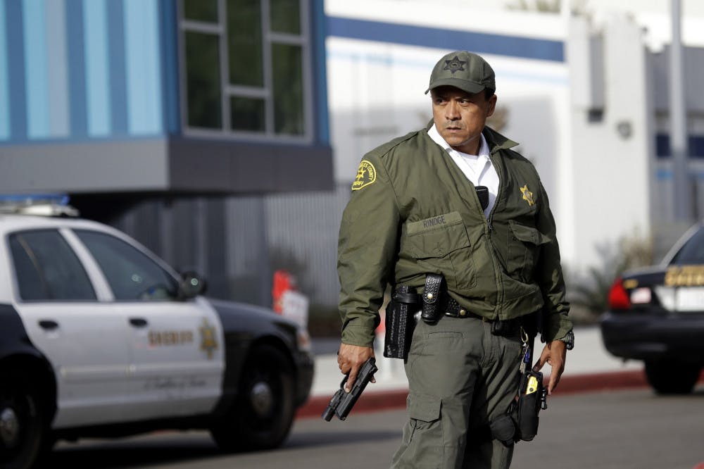 <p>A member of the Los Angeles County Sheriff Department stands outside of Saugus High School with his weapon drawn after reports of a shooting on Thursday, Nov. 14, 2019, in Santa Clarita, Calif. (AP Photo/Marcio Jose Sanchez)</p>