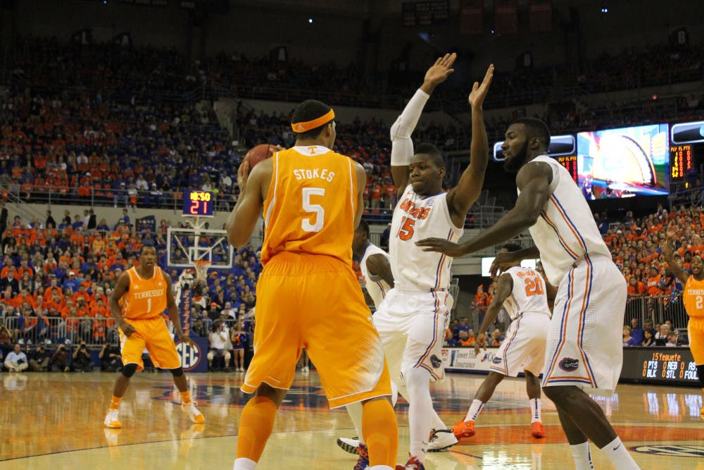 <p>Will Yeguete (middle) and Patric Young (right) cover Tennessee forward Jarnell Stokes during Florida’s 67-41 win against Tennessee on Saturday in the O’Connell Center.</p>