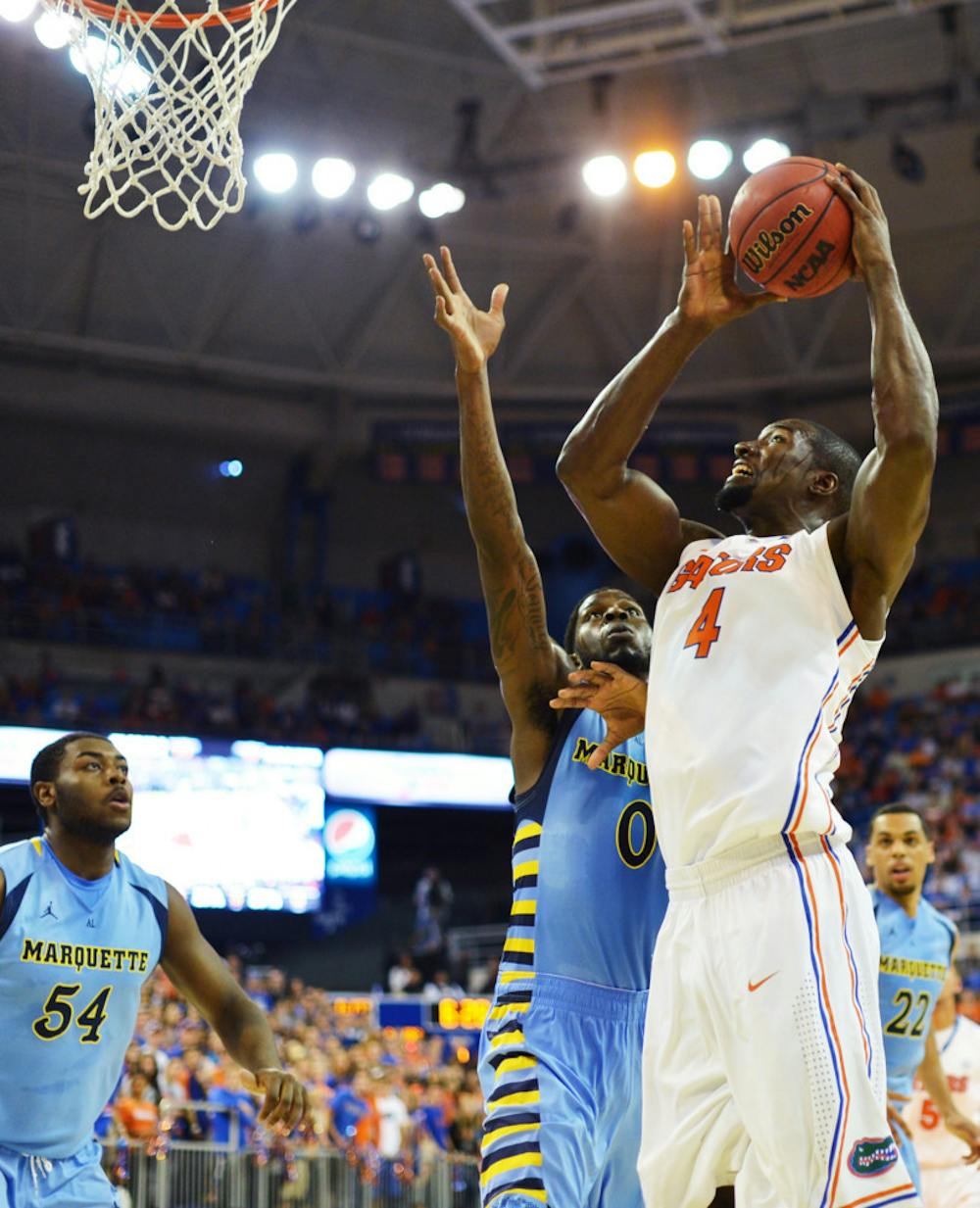 <p>Junior Patric Young goes for a layup over Marquette forward Jamil Wilson at the O’Connell Center on Nov. 29. Young headlines a group of 11 returning players.</p>