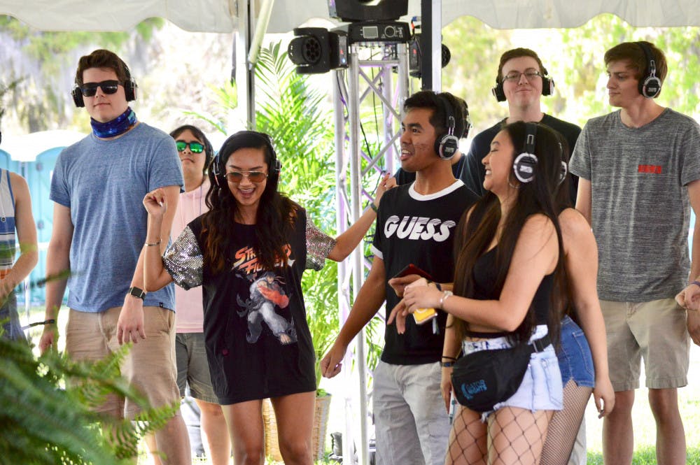 A group of students dance at a "Silent Disco" held during The Wetlands Music Festival on Sunday. The event featured headlining artist A$AP Ferg, food trucks, an art walk and other activities. 