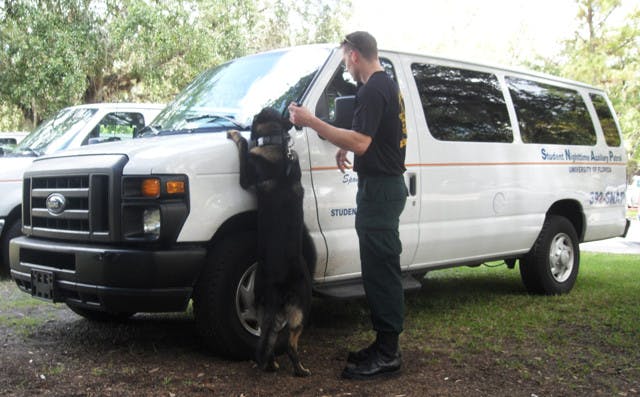 A German shepherd police dog, Apollo, is led by Marion County Sheriff's Office Deputy Greg Combs Friday, sniffing out narcotics for his yearly certification requirements.