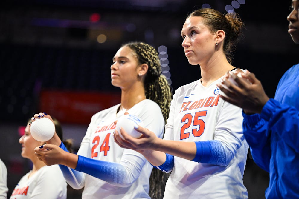Florida Gators middle blocker Alec Rothe (25) and outside hitter Lauren Harden (24) stand during the lineup announcement before a volleyball match against PVK Olymp Praha of the Czech Republic, on Tuesday, Aug. 26, 2025, at the O'Connell Center in Gainesville, Fla.