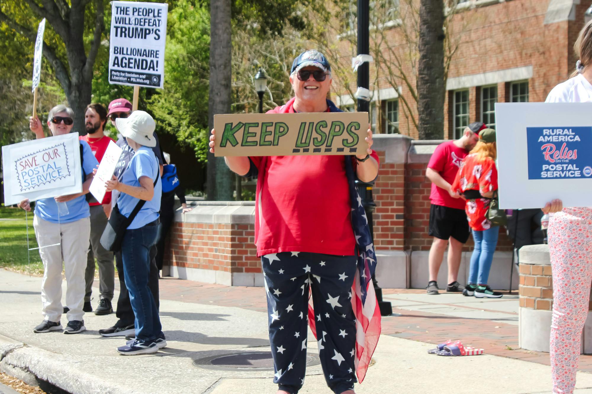 Mail workers protest the Trump administration’s proposed cuts to the United States Postal Service in Gainesville, Fla. on Sunday, March 23, 2025.