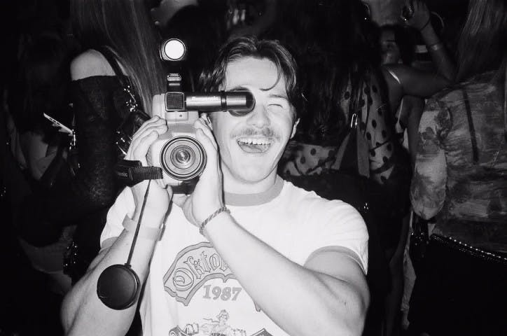 Evan Stice holds a retro camera at Simons nightclub on Wednesday, November 20, 2024.