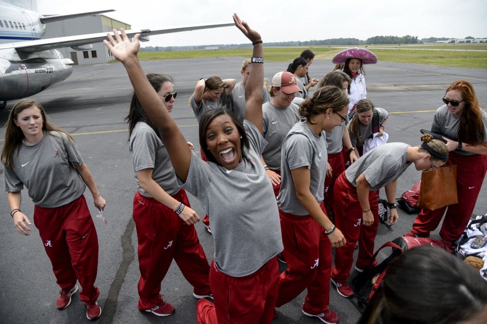 <p>Alabama outfielder Andrea Hawkins cheers as the softball team gathers its bags before boarding a flight to Oklahoma City for the NCAA Women's College World Series on Tuesday in Tuscaloosa, Ala.</p>