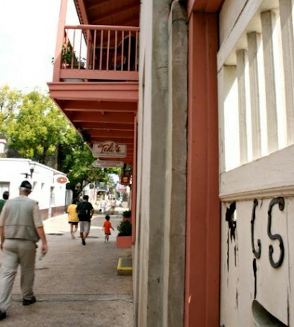 <p>People walk past the Benet House, now Tedi's Olde Tyme Ice Cream, in downtown St. Augustine on a Tuesday afternoon in September 2008.&nbsp;</p>