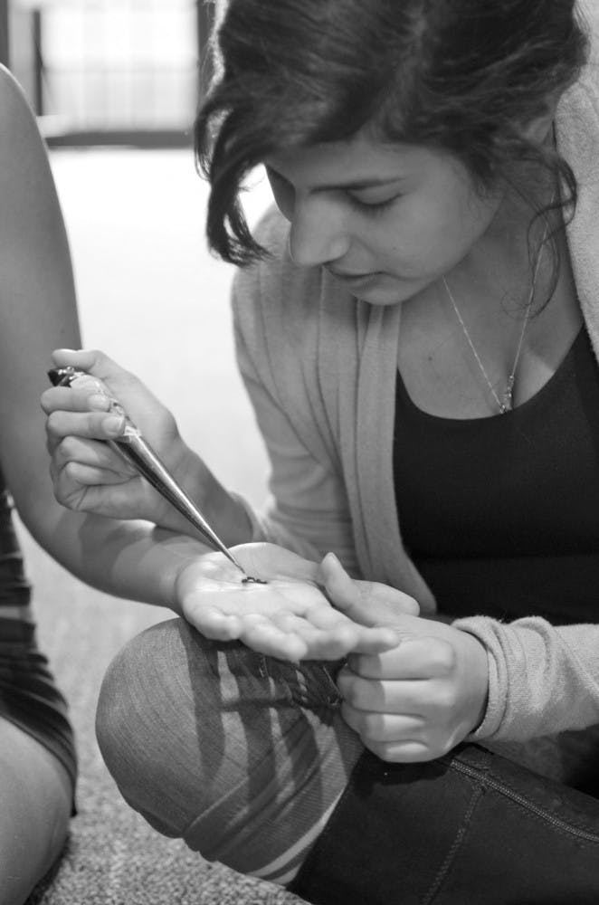 Jeena Kar, a 22-year-old UF arts in medicine graduate student, practices her henna drawings on Natalie Bonilla, a 21-year-old UF health sciences student, in the University Auditorium. Kar will donate her skills and time on campus to help three Dance Marathon captains. She will charge $5 for her designs with proceeds going towards Dance Marathon, a 26.2-hour event benefiting the patients of UF Health Shands Children's Hospital.