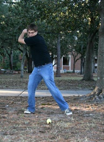 FORE! Jeremiah Tattersall, a UF senior, plays urban golf on the Plaza of the Americas Sunday afternoon. Tattersall said he gathers with friends to play every Wednesday. Urban golf is a sport where people choose their own tee-off area and hole in an urban or unconventional location. (Charlie Doerner / Alligator)