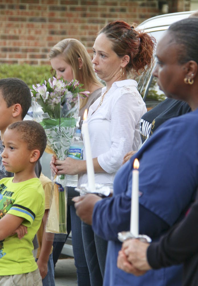 Jennifer Appel mourns her son, Robert Dentmond, who died at a Gainesville apartment building last week, at Powerhouse Church on Monday night. About 30 people, including both family and strangers, showed up for the candlelit service.