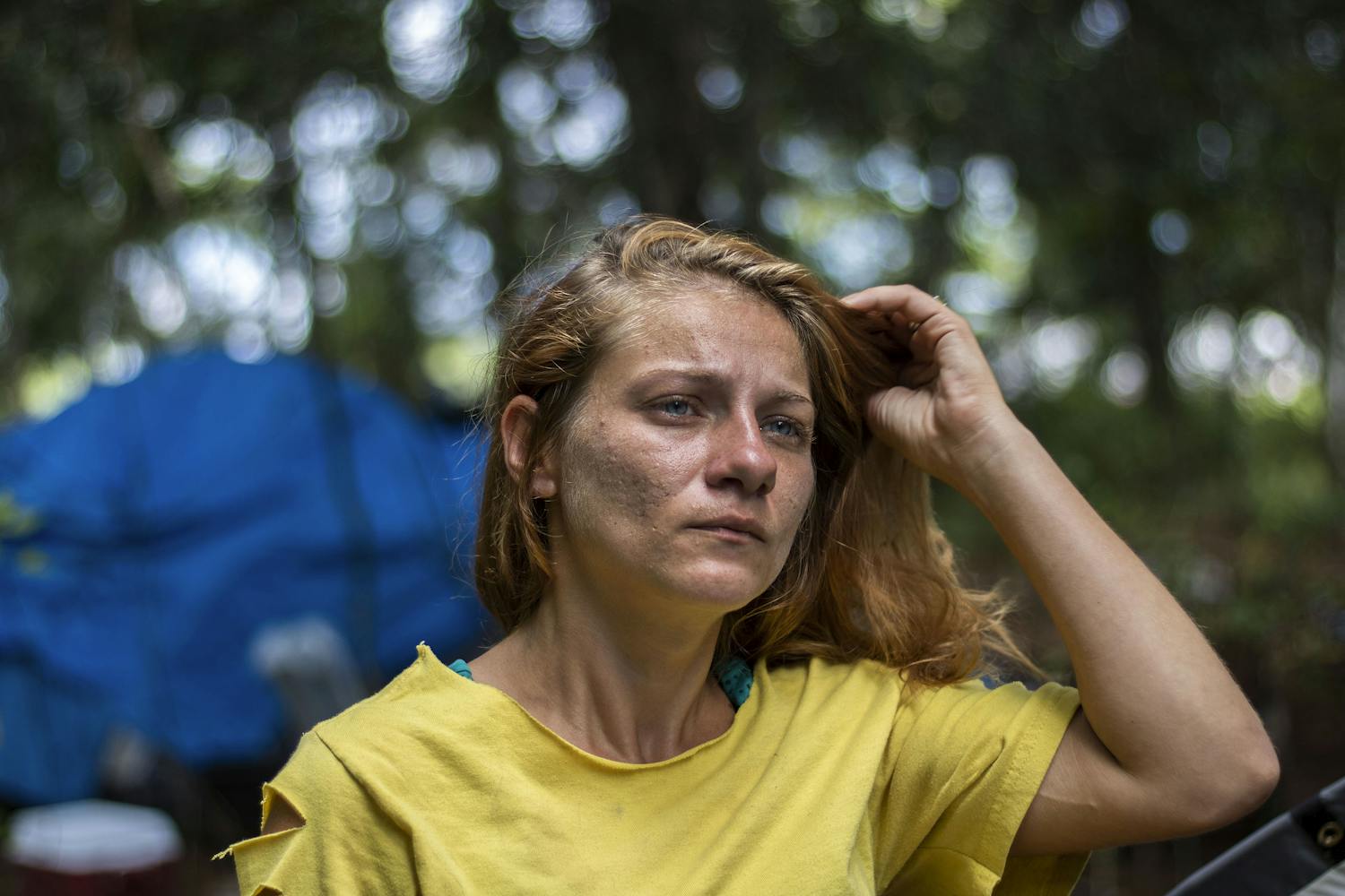 Amanda Smith, a 31-year-old Dignity Village resident, stands in front of her camp located on the outskirts of the 10-acre property. Smith has lived there for four months. She wants to stay in Gainesville once it closes on Jan. 1, though she does not know where she will go.