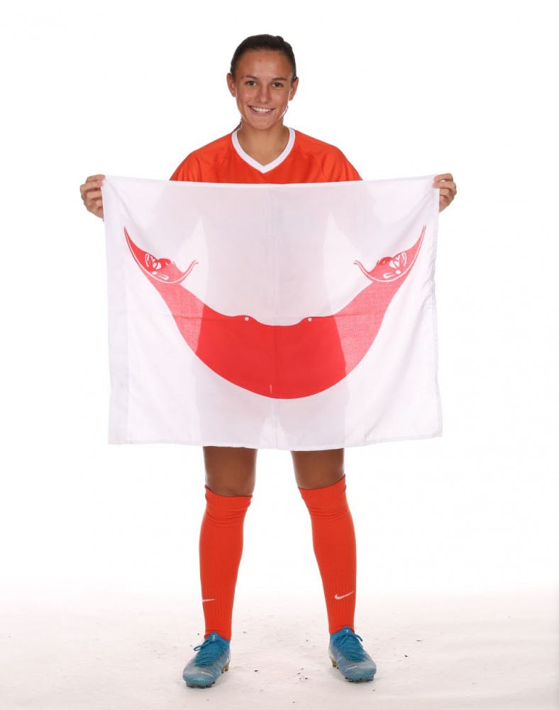 Kadzban holds the Rapa Nui flag. The flag depicts a Reimiro, a moon-shaped ornament worn by Easter Island natives, and two heads at each end of it.