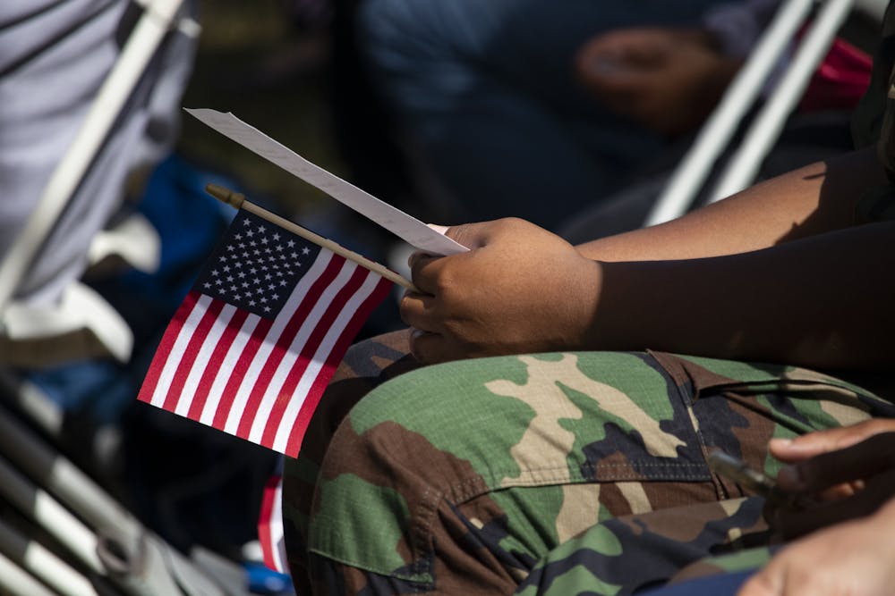 <p>One of the Milton Lewis Young Marines holds a small flag during the Veterans Day event at the Historic Evergreen Cemetery.</p>