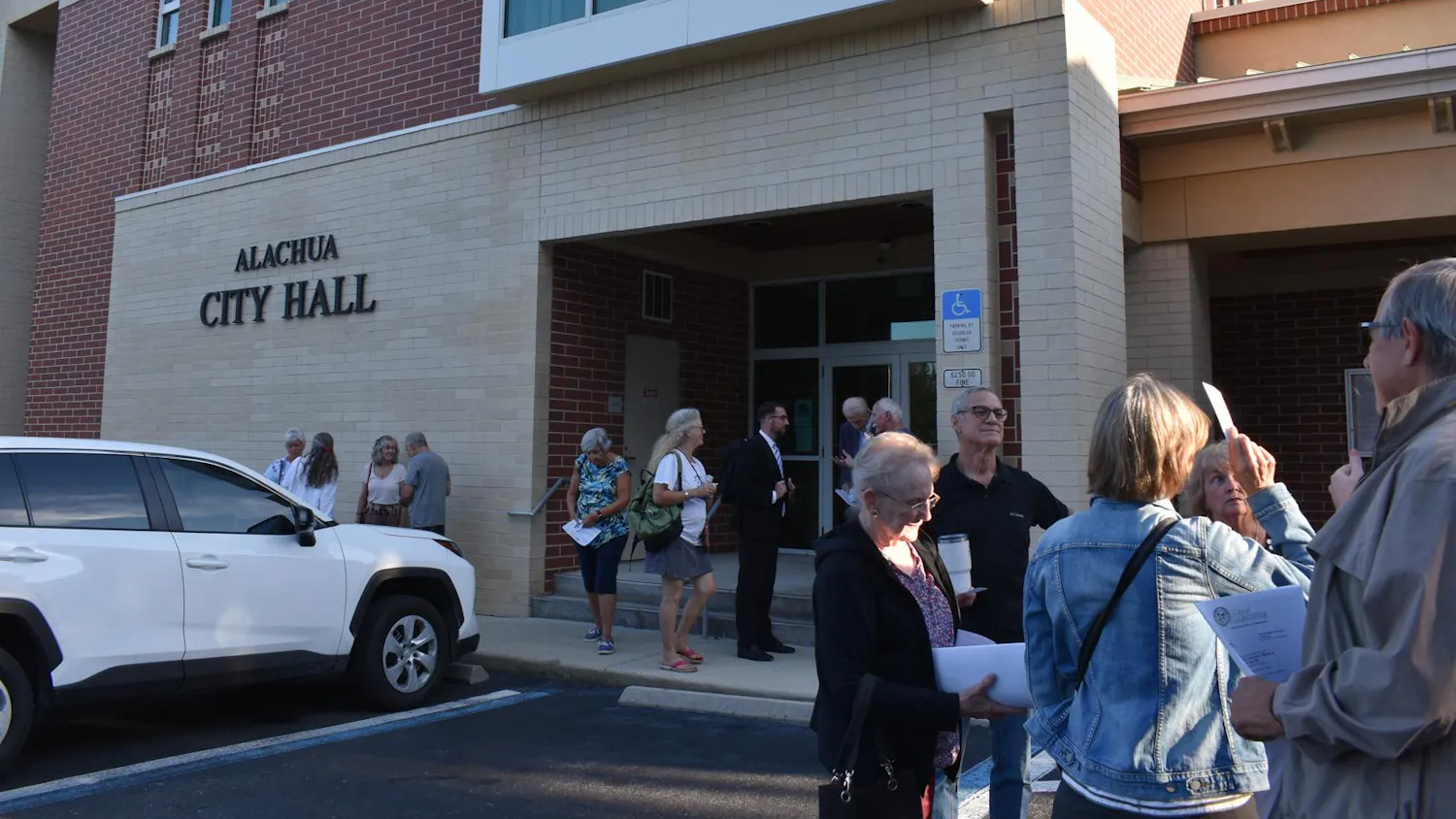 Residents gather outside Alachua City Hall after the city commission meeting was cancelled Monday, Sept. 28, 2026 in Alachua, Fla.