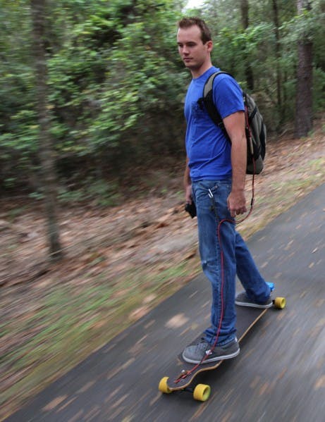 Aaron King, UF alumnus and founder of RedRock Board Shop, rides down the Gainesville-Hawthorne State Trail on one of his electric longboards Oct. 9. The electronics for a board cost $300.
