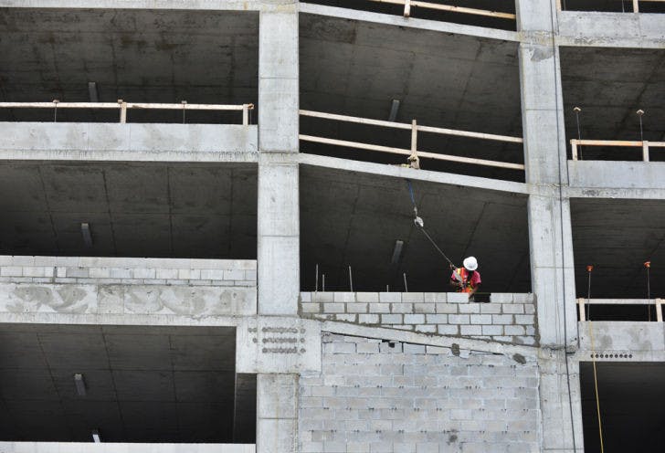 A construction worker lays bricks while working on a new parking garage Wednesday afternoon behind Roberts’ Stadium Club on University Avenue. It should be completed in August.
&nbsp;