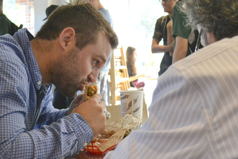 <p>Kevin Paule (left), a 25-year-old UF third-year law student, chomps into his burrito at Chipotle on Nov. 3, 2015, while out to lunch with Craig DeThomasis, a UF trial practice professor. DeThomasis said he wasn’t worried about E. coli in the Chipotle chains on the West coast. “Life’s a risk,” he said.</p>