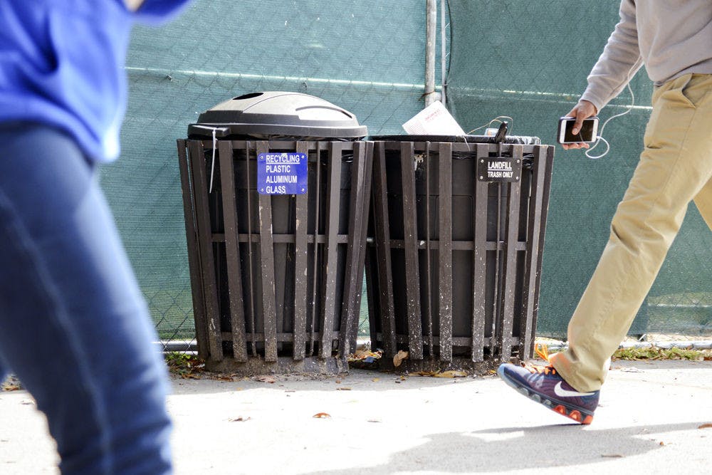 University of Florida students pass in front of the recycling and trash bins near Weimer Hall on Monday afternoon. Ginnie Springs management is encouraging park visitors to deposit their trash in bins and not litter.