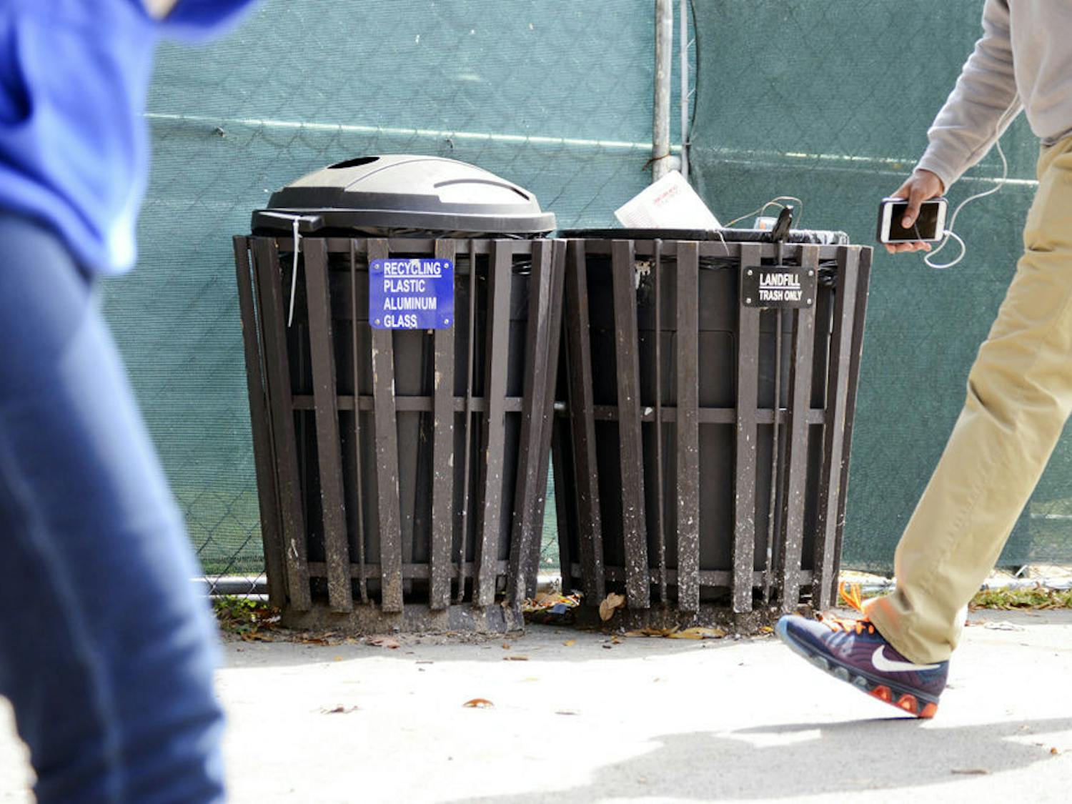 University of Florida students pass in front of the recycling and trash bins near Weimer Hall on Monday afternoon. Ginnie Springs management is encouraging park visitors to deposit their trash in bins and not litter.