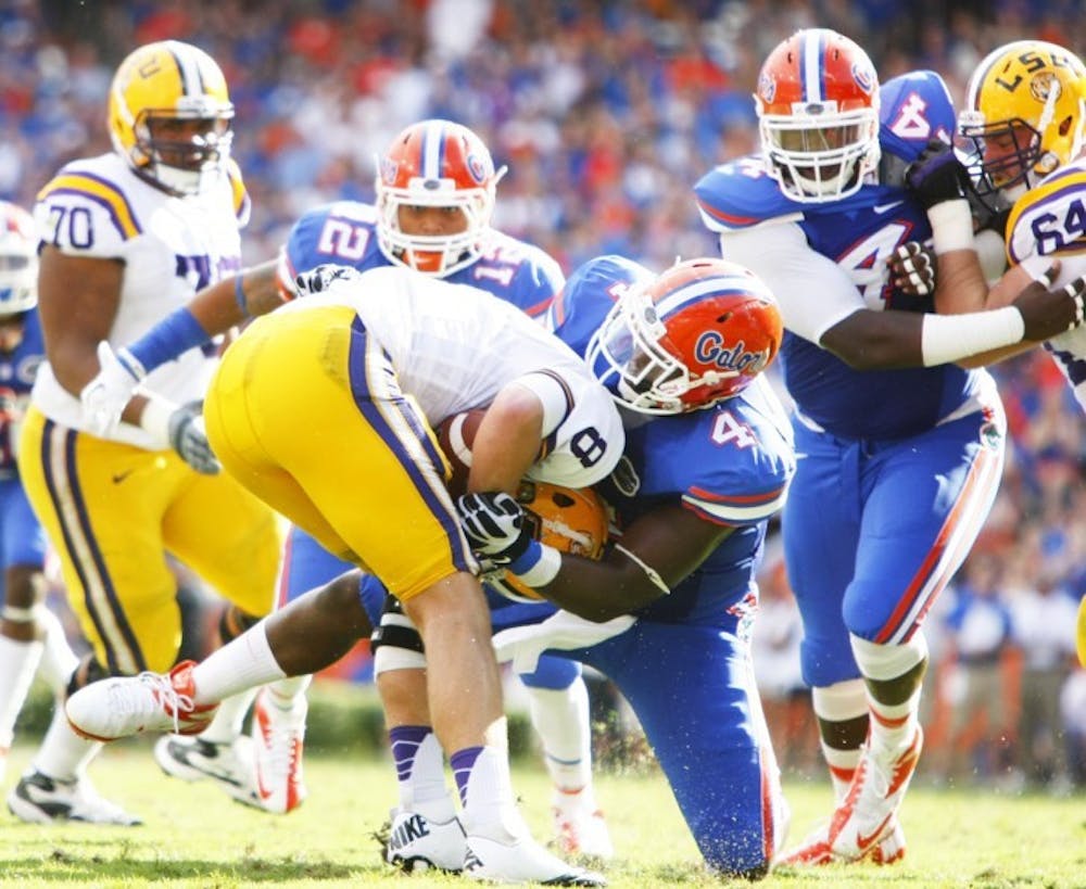 <p>Junior Damien Jacobs (4) sacks LSU quarterback Zach Mettenberger (8) in the second quarter of Florida's 14-6 victory on Saturday in Ben Hill Griffin Stadium. The Gators had a season-high four sacks in the win.</p>