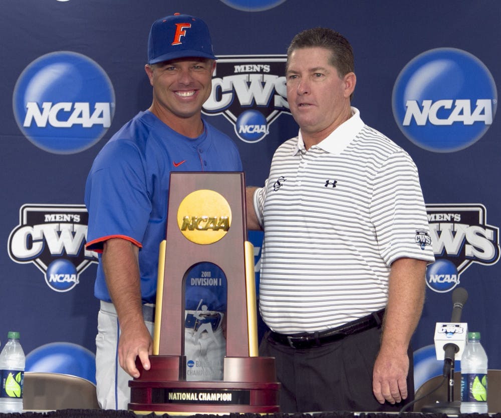 Florida baseball coach Kevin O'Sullivan, left, and South
Carolina coach Ray Tanner pose with the College World Series
trophy. The Gators and Gamecocks will play a best-of-three
championship series starting Monday at 8 p.m.