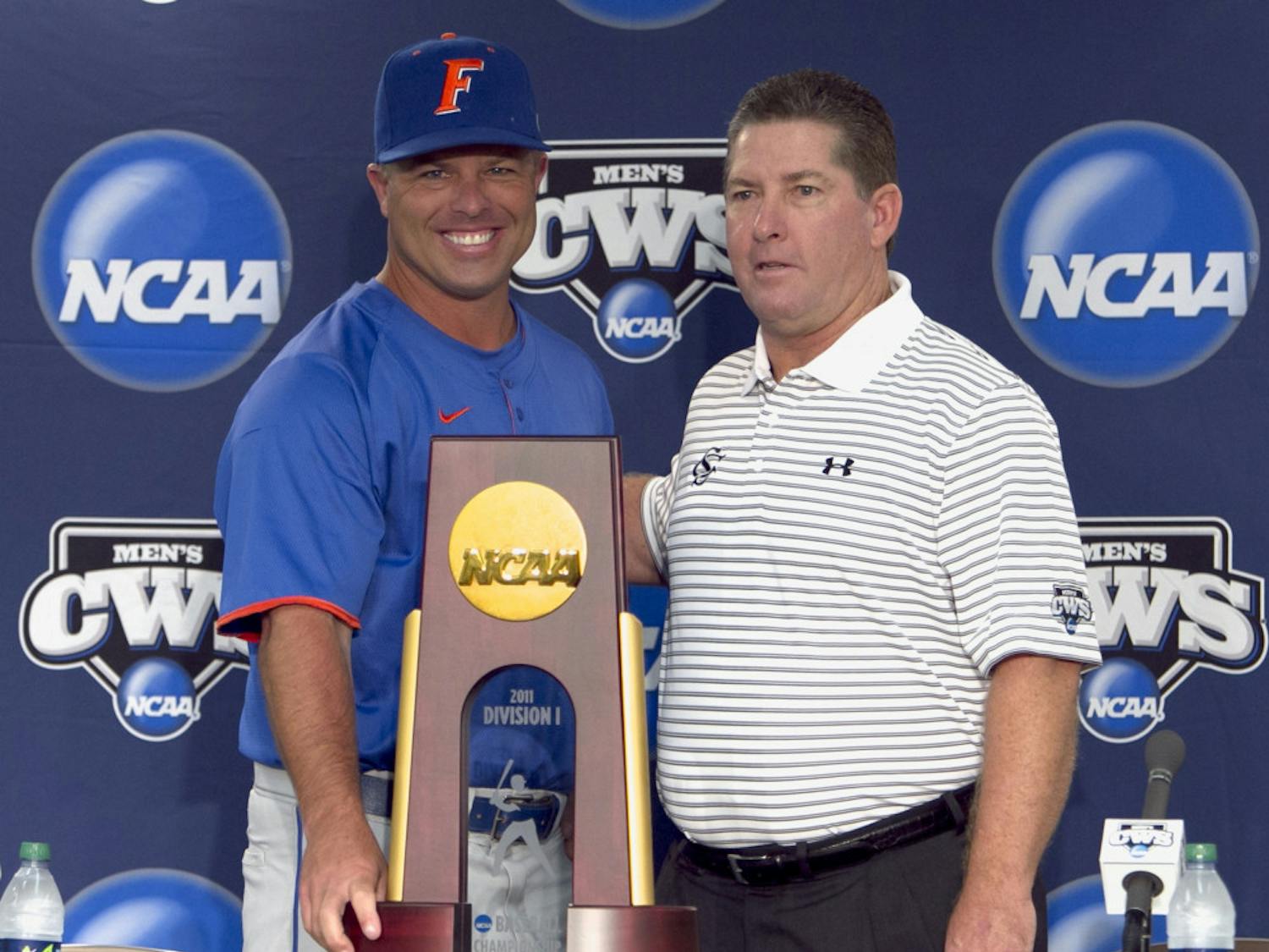 Florida baseball coach Kevin O'Sullivan, left, and South
Carolina coach Ray Tanner pose with the College World Series
trophy. The Gators and Gamecocks will play a best-of-three
championship series starting Monday at 8 p.m.