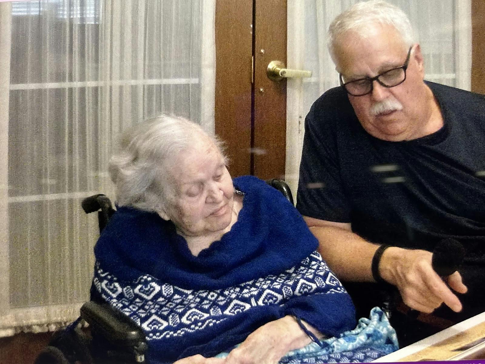 Holocaust survivor Francine Taylor (left) looks at pictures from World War II on Oct. 8, 2023, with her son (right), Forrest Allen Taylor, in a document made by a former College of Charleston student. 