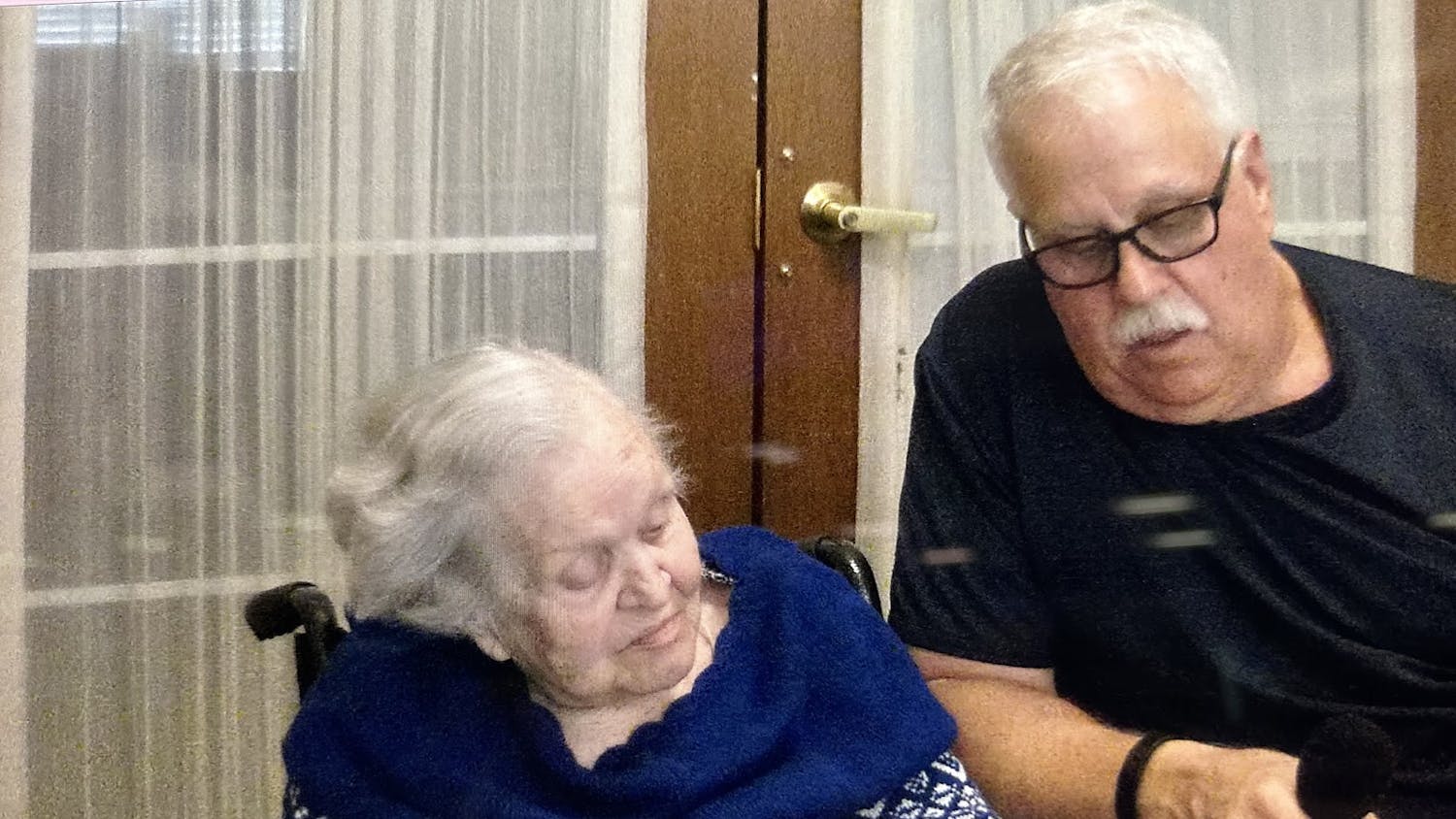 Holocaust survivor Francine Taylor (left) looks at pictures from World War II on Oct. 8, 2023, with her son (right), Forrest Allen Taylor, in a document made by a former College of Charleston student.