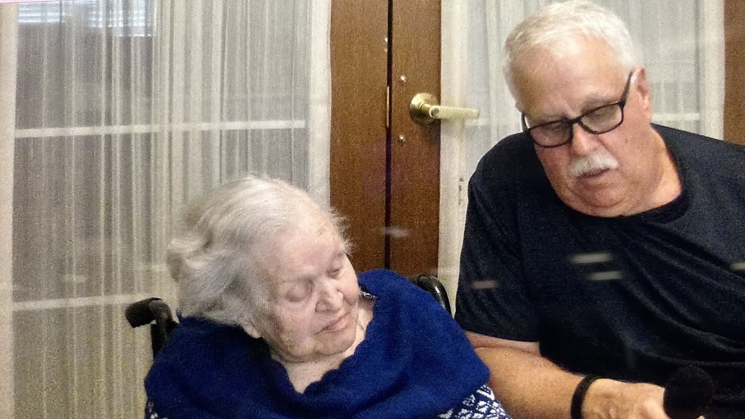 Holocaust survivor Francine Taylor (left) looks at pictures from World War II on Oct. 8, 2023, with her son (right), Forrest Allen Taylor, in a document made by a former College of Charleston student. 