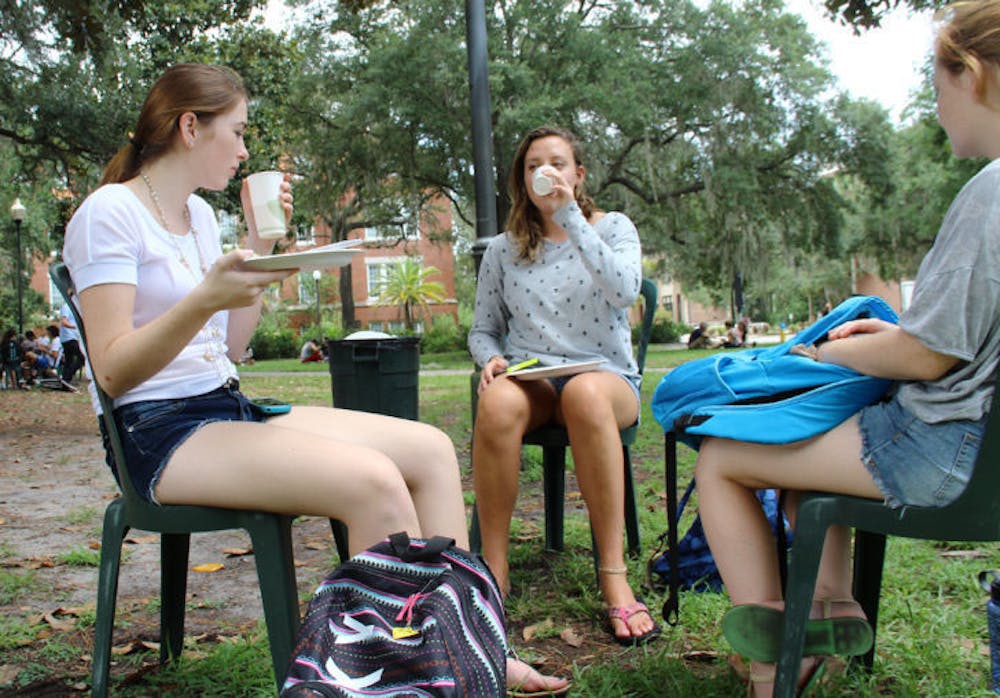 <p>International studies freshman Kelly Collin, 18, and environmental science freshman Avalon Hoek Spaans, 18, eat Krishna Lunch on paper plates Wednesday. Krishna switched from reusable plates to paper ones.</p>