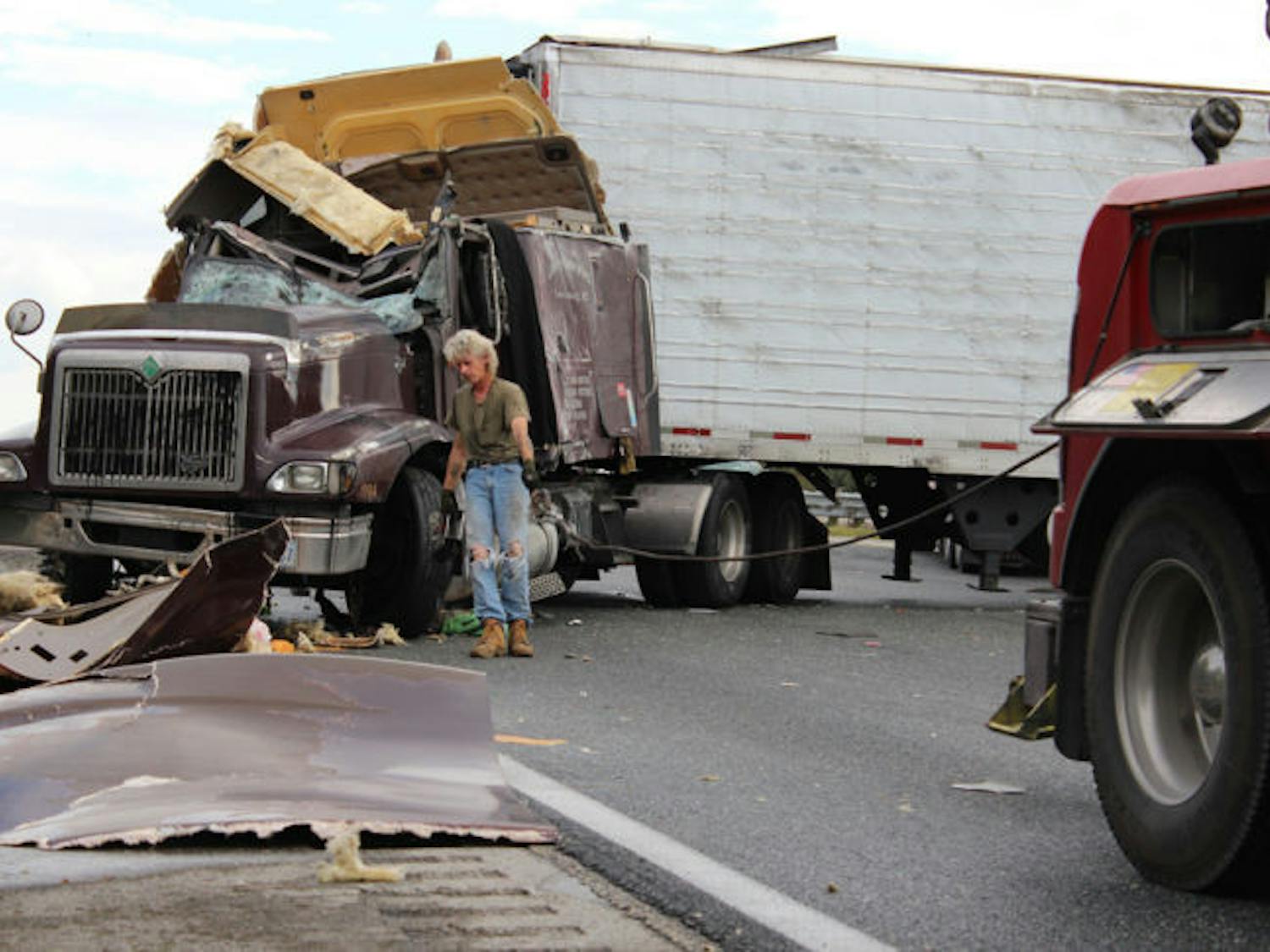 University Towing &amp; Transport Inc. worker Jerry Bailey prepares to tow a semitruck after an accident that left the truck overturned, blocking all three northbound lanes on Interstate 75 near the Micanopy exit on Saturday afternoon.