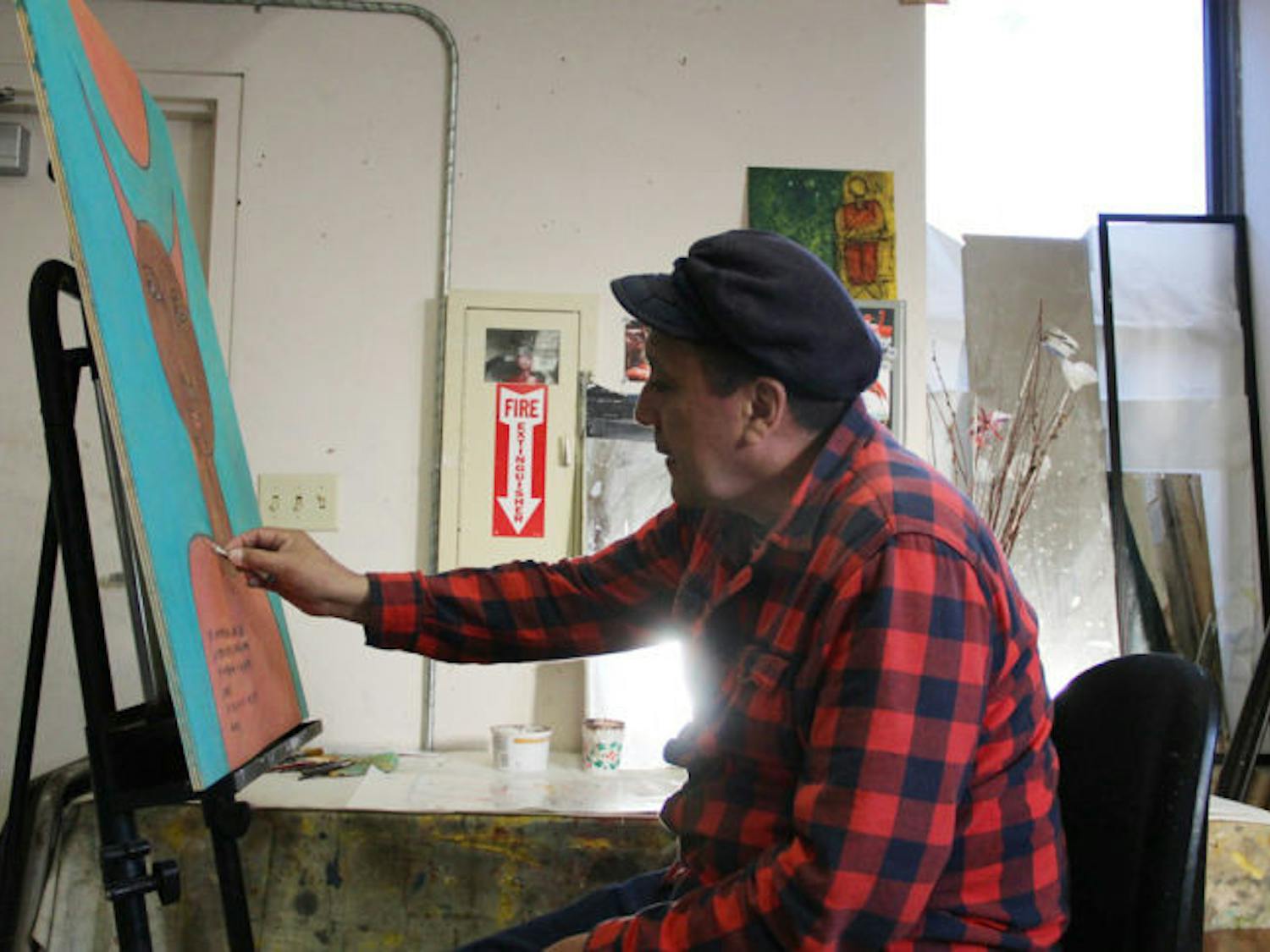 Local artist Marco Razo, 50, puts some finishing touches on his latest painting at Sweetwater Print Co-Op, 117 S. Main St., Saturday afternoon. His new exhibition, Meditaciones de un Quijote (Meditations of a Quixote), is opening Feb. 19 at the Hippodrome Gallery, 25 SE Second Place.