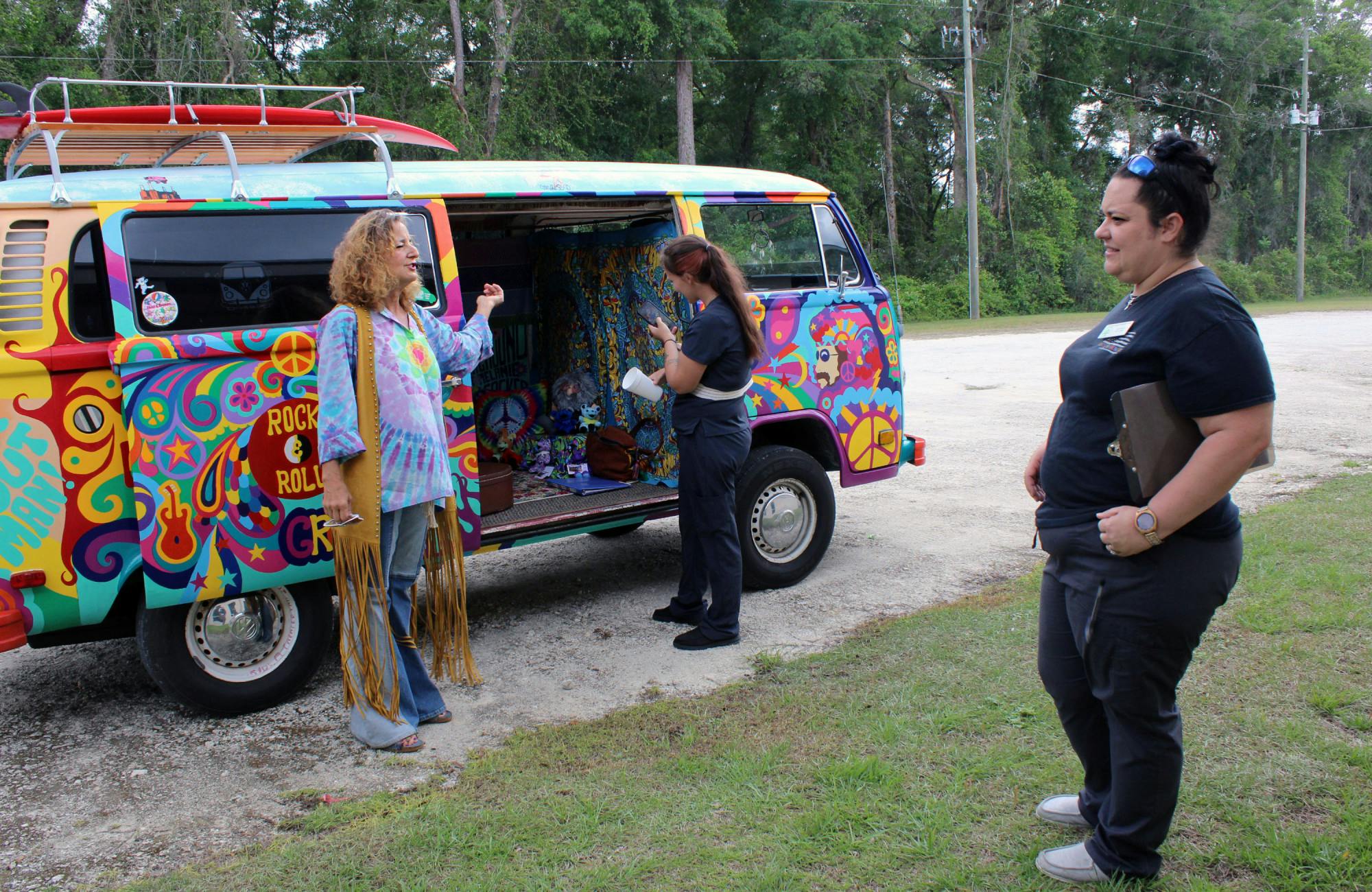 Elaine Hargrove (left) shows off her hand-painted 1978 Volkswagen bus to Tri-County Nursing Home staff on on Tuesday, April 11, 2023. Crystal Ellison (right) invites Hargrove to perform for the residents once a month.