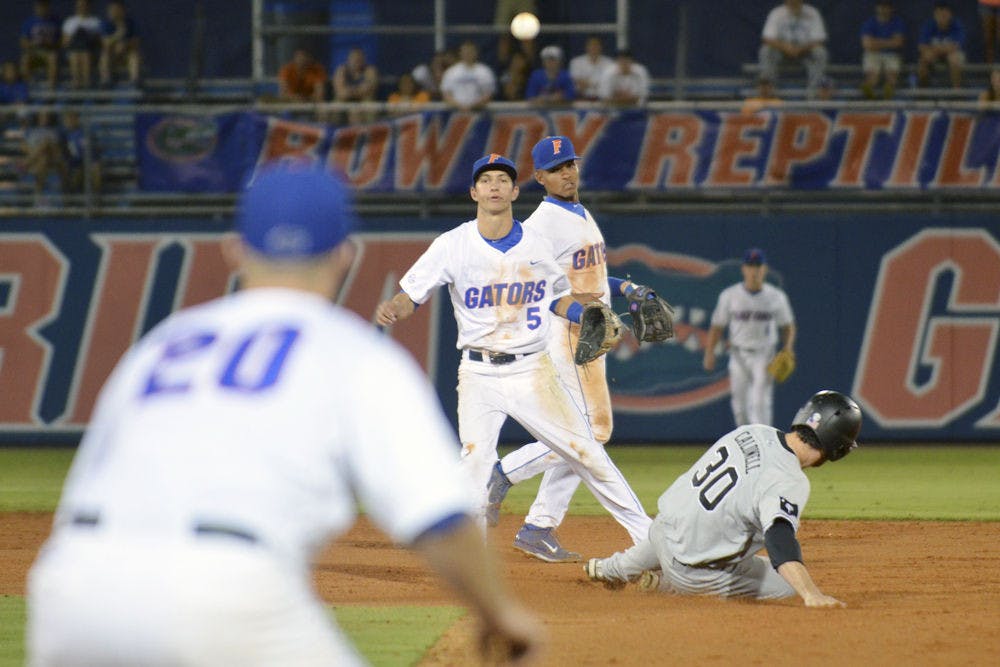 Dalton Guthrie (5) throws the ball to first baseman Peter Alonso (20) for a double play during Florida's 14-3 win against South Carolina on April 10, 2015, at McKethan Stadium.