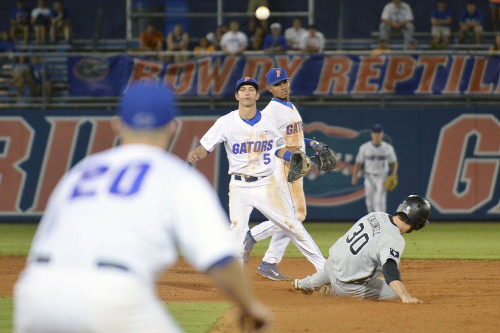 <p>Dalton Guthrie (5) throws the ball to first baseman Peter Alonso (20) for a double play during Florida's 14-3 win against South Carolina on April 10, 2015, at McKethan Stadium.</p>