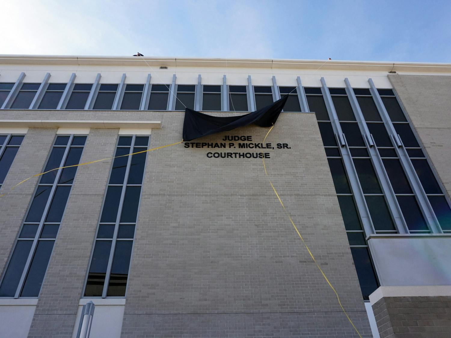 A cut ribbon reveals a new sign for the Alachua County Courthouse at the renaming ceremony in honor of the late Judge Stephan P. Mickle on Friday, Jan. 14. 