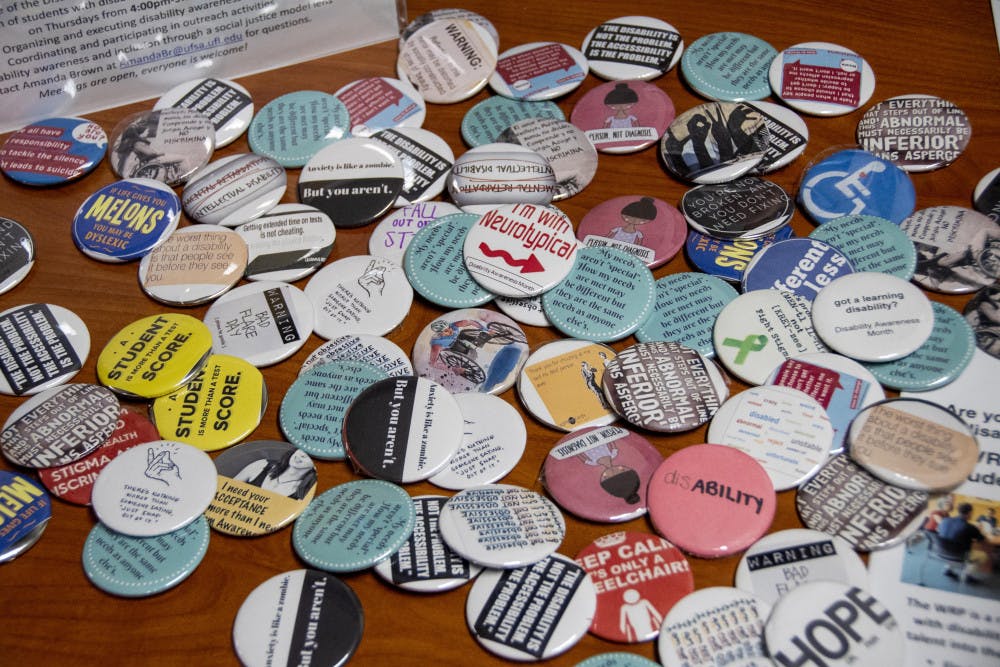 Pins are passed out with words of encouragement at the UF Disability Advocacy Assembly Thursday night. The event, which aimed towards building a more inclusive and aware campus, took place at Cypress Hall.