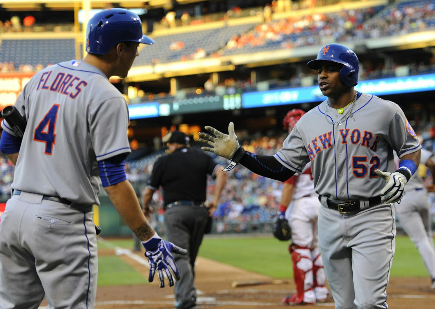 New York Mets' Yoenis Cespedes (52) celebrates with teammate Wilmer Flores after scoring a run on a Michael Cuddyer double in the first inning of a baseball game against the Philadelphia Phillies, Wednesday, Aug. 26, 2015, in Philadelphia. (AP Photo/Michael Perez)