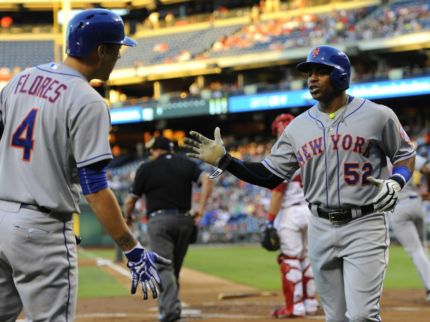New York Mets' Yoenis Cespedes (52) celebrates with teammate Wilmer Flores after scoring a run on a Michael Cuddyer double in the first inning of a baseball game against the Philadelphia Phillies, Wednesday, Aug. 26, 2015, in Philadelphia. (AP Photo/Michael Perez)