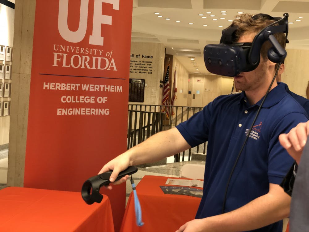 <p>Adam Lizek, a 20-year-old UF computer science junior, uses virtual reality as part of the College of Engineering’s Gator Day display. The college is researching virtual reality applications in education to create smart classrooms, Lizek said.</p>