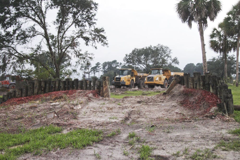 Dump trucks sit in the lot of what used to be Windmeadows Mobile Home Park, which has been empty and covered in overgrown grass since 2002. A 100-acre expansion of Butler Plaza will be built there.