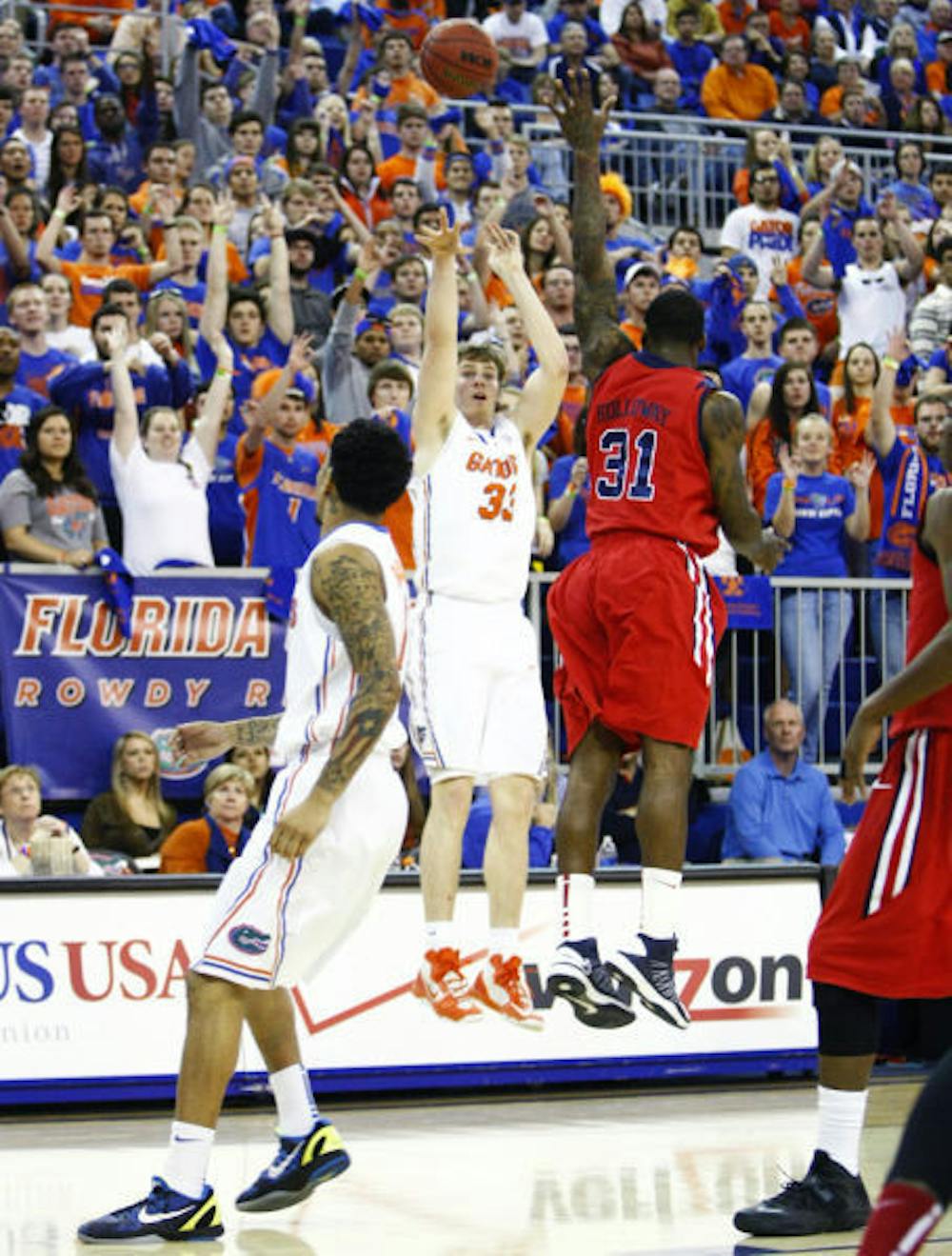 <p>Senior forward Erik Murphy (33) attempts a three-point shot over Ole Miss forward Murphy Holloway (31) on Saturday at the Stephen C. O'Connell Center. Murphy scored 19 points during Florida's 78-64 victory over Ole Miss.</p>