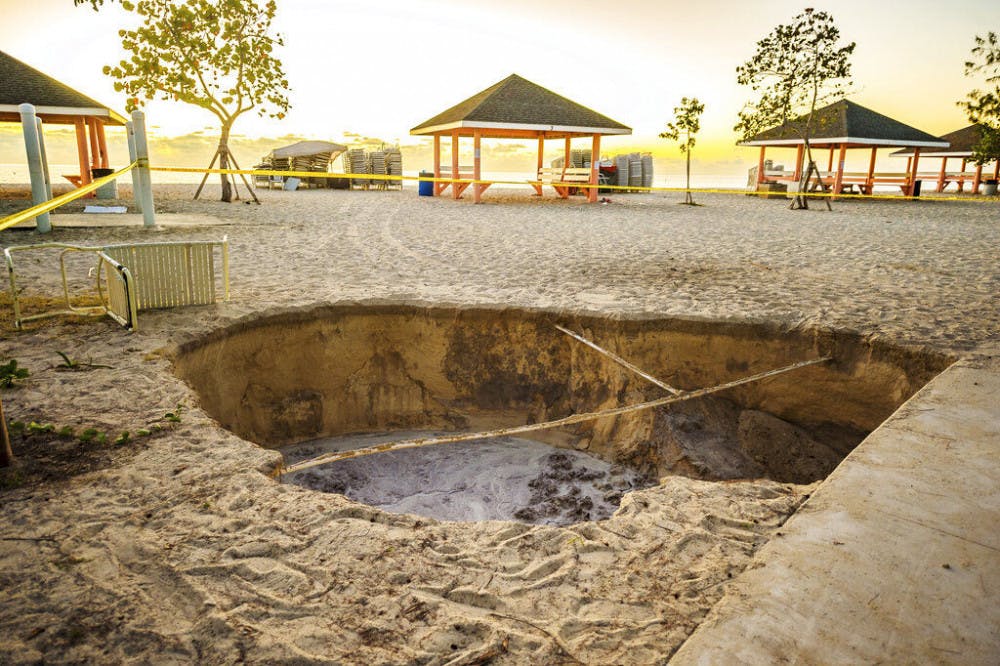 <p>A sinkhole is surrounded by police tape after it appeared when a powerful magnitude 7.7 earthquake struck in the Caribbean Sea between Jamaica and eastern Cuba, at Public Beach on West Bay, Grand Cayman, Tuesday, Jan. 28, 2020. The quake also hit the Cayman Islands, leaving cracked roads and what appeared to be sewage spilling from cracked mains. There were no immediate reports of deaths, injuries or more severe damage. (Taneos Ramsay/Cayman Compass via AP)</p>