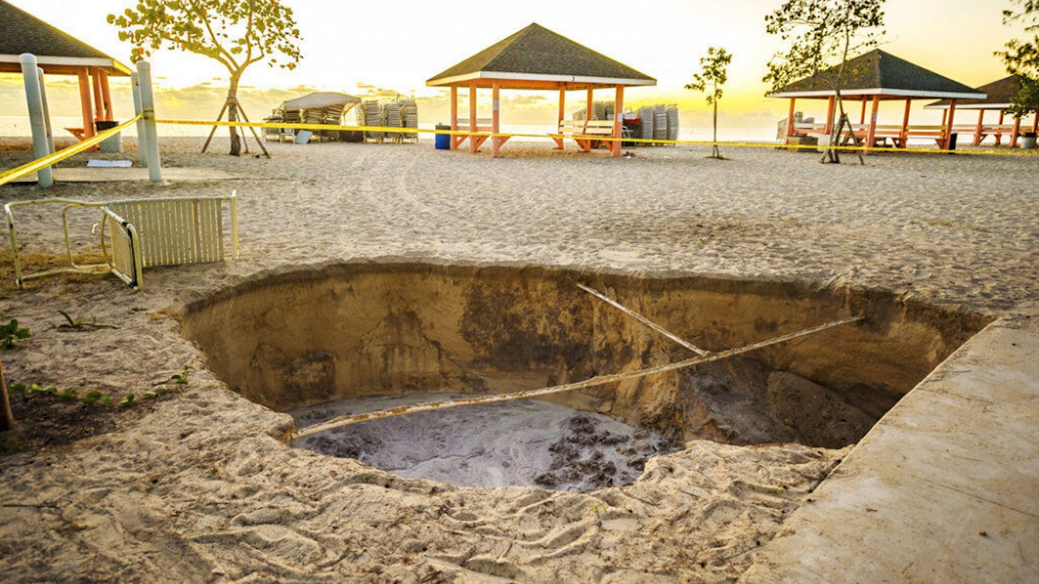 A sinkhole is surrounded by police tape after it appeared when a powerful magnitude 7.7 earthquake struck in the Caribbean Sea between Jamaica and eastern Cuba, at Public Beach on West Bay, Grand Cayman, Tuesday, Jan. 28, 2020. The quake also hit the Cayman Islands, leaving cracked roads and what appeared to be sewage spilling from cracked mains. There were no immediate reports of deaths, injuries or more severe damage. (Taneos Ramsay/Cayman Compass via AP)