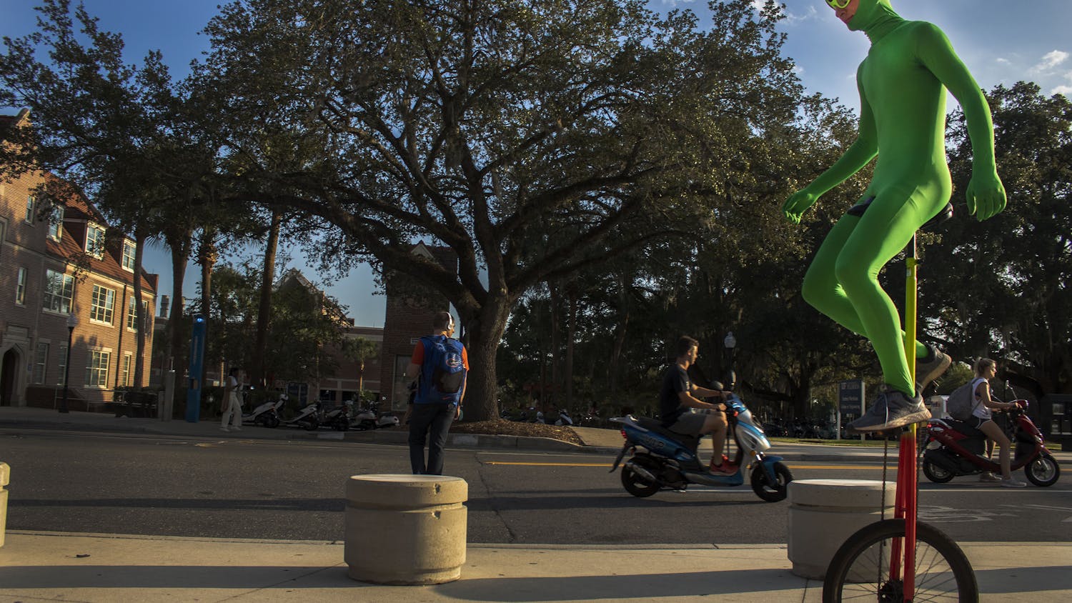 Ethan Gamble, 17-year-old Gainesville High student, rides his unicycle down Stadium Road while wearing his green alien outfit. Gamble said he first started by riding around the bus loop at JJ Finley Elementary school. “You just have to practice,” Gamble said. “Until you get the feel of it.”
